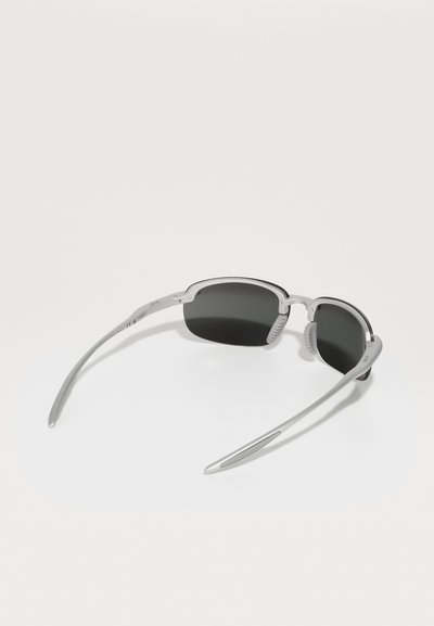 Lunettes de sport avec une monture en plastique argenté, au design élégant, verres teintés noirs et branches courbées pour un ajustement sécurisé.