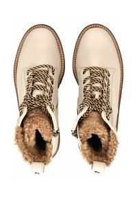 Botas de tobillo de cuero crema con grueso forro de piel sintética, cordones trenzados en negro y beige, y suela texturizada. Detalle de cremallera en el lateral.