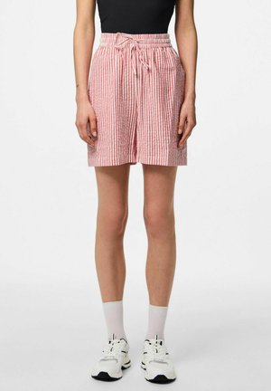 Rood-witte gestreepte shorts met een trekkoord in de taille, gemaakt van lichtgewicht stof, knie-lengte met een relaxte pasvorm, gecombineerd met witte sneakers.