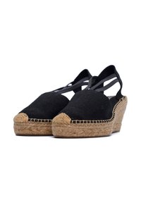 Czarne zamszowe czółenka na koturnie z plecioną platformą z juty, zaokrąglony nosek i krzyżujące się paski na kostce. Teksturowana górna część z płótna i plecione detale.