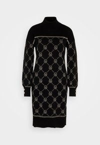 Svart långärmad stickad klänning med hög hals, silverfärgad diamantram med cirkulära logotyper och knapprera detaljer på ärmslut och axel.