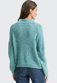 Türkisfarbener Strickpullover mit hohem Kragen, gerippten Bündchen und legerer Passform; verfügt über ein strukturiertes Muster und eine leicht verkürzte Länge.