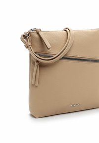 Beige leather handbag featuring a textured finish, zip closure, and a detachable shoulder strap with tassel detail. Silver logo accent.