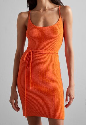 Ribbed orange dress with spaghetti straps, form-fitting shape, and waist tie detail. The texture is soft and woven, enhancing the bright color.