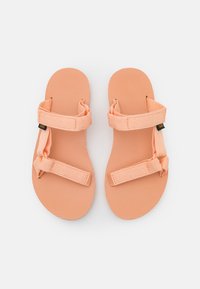 Sandalias de color durazno con una superficie texturizada, correas de tela y cierres ajustables. Diseño ligero adecuado para uso casual.