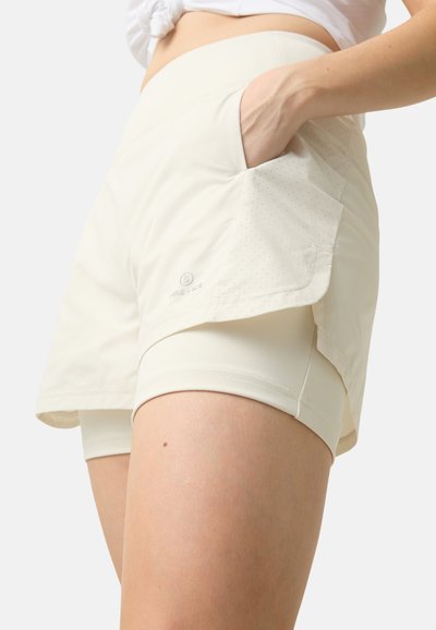 Lichtbeige sportshorts met een aangesloten binnenlaag, zijzak en geperforeerde details. Gemaakt van soepele, rekbare stof voor comfort.
