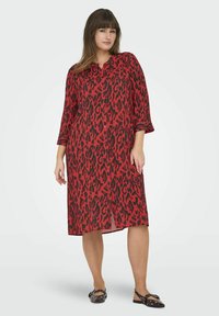 Rode shirtjurk met luipaardprint, knoopsluiting aan de voorkant, driekwartmouwen en een relaxed fit. Heeft een soepele, lichte stof.