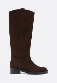 Hnedé semišové čižmy po kolená s okrúhlou špičkou a masívnym čiernym podpätkom. Obsahujú pútko na vrchu a jemný šev na bokoch.