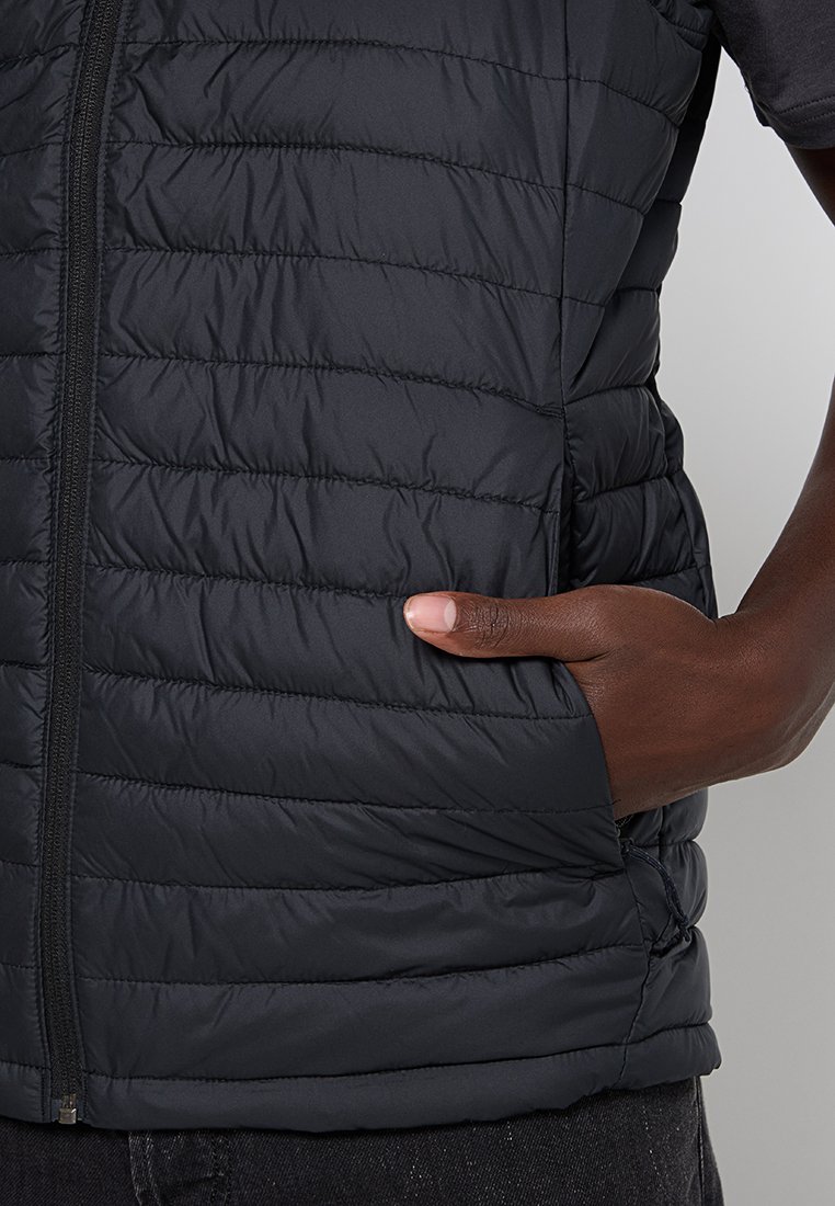 Gilet imbottito nero con sezioni trapuntate, chiusura con zip e tasca laterale. Il materiale sembra leggero e dalla texture liscia.
