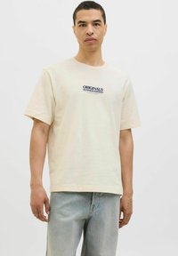 Cream cotton t-shirt with a relaxed fit, featuring a navy print that reads "ORIGINALS SUMMER EDITION" on the chest. Short sleeves.