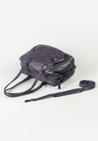 Borsa a tracolla in pelle viola con due manici, tracolla, chiusura con zip e una superficie liscia. Presenta una forma arrotondata e cuciture a contrasto.