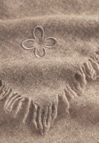 Écharpe en laine marron avec un délicat motif de fleurs brodé. Présente des bords à franges et une texture douce.