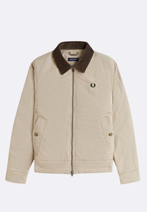 Beige jas met een bruine corduroy kraag, ritssluiting en twee zijzakken. Heeft een klein geborduurd embleem op de borst.