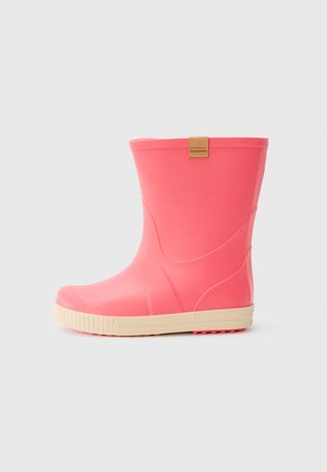 Stivale da pioggia in gomma rosa di altezza media con suola beige e piccola etichetta marrone vicino alla parte superiore su uno sfondo grigio chiaro uniforme.