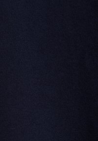 Texture en tissu tricoté bleu marine uni avec un motif de couture fin et uniforme et de légères variations de teinte.
