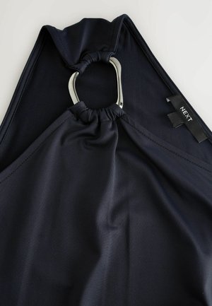 Vêtement en tissu bleu marine avec un design froncé et un accent en anneau en métal argenté. Présente une étiquette portant la mention "NEXT", indiquant la marque.