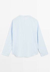 Lichtblauw langemouwshirt met een ontspannen pasvorm. Voorzien van een ronde halslijn en subtiele textuur door de stof voor extra detail.