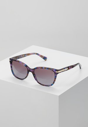 Lunettes de soleil en écaille de tortue violette et bleue avec verres dégradés et détails en métal doré, présentant une forme légèrement surdimensionnée en œil de chat.