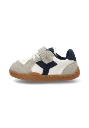 Zapatilla para niño pequeño con parte superior de ante blanco y gris, acentos de tela azul marino, cierre de velcro, cordones blancos y suela de goma color goma, vista lateral sobre fondo blanco.