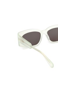 Ochelari de soare cat-eye verde deschis, cu lentile întunecate, având o ramă transparentă și accente subtile de aur pe braț.