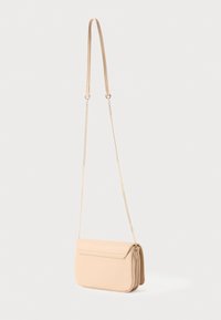 Bēša ādas crossbody soma ar atloku, kurai ir gara zelta ķēdes siksna un izšūti detaļas uz baltā fona.