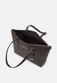 Borsa a tracolla marrone con motivo, chiusura con zip, interno nero, due manici e logo dorato. Presenta un'etichetta staccabile.
