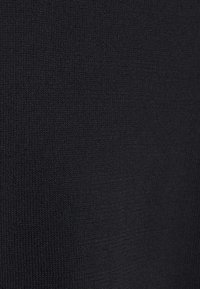 Musta resorikuvioitu neuloskangas, jossa on sileä pinta ja tasainen rakenne. Koko pinnalla on yhtenäinen kuvio ilman näkyviä korostuksia tai yksityiskohtia.