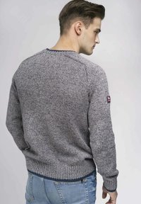 Maglione grigio in maglia con un motivo testurizzato, polsini e orlo a costine, e un orlo del collo blu navy. Presenta una piccola bandiera britannica sulla manica.