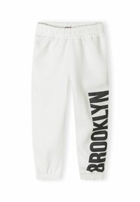 Vita sweatpants med elastiskt midjeband, prydda med en svart "BROOKLYN" grafik längs vänster ben. Mjuk textur, avsmalnande ärmslut.