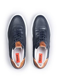 Granatowe skórzane sneakersy z siateczkowymi detalami, okrągłym noskiem i kontrastującymi tanowymi akcentami. Posiadają białą gumową podeszwę i czarne sznurowadła.