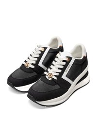 Schwarz-weiße Sportschuhe mit einem strukturierten Stoff-Obermaterial, goldfarbenen Ösen, dickem Sohlen und Schnürdesign, das kontrastierende Streifen aufweist.