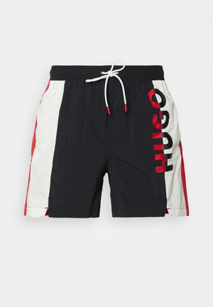 Herren Badeshorts in Navy, mit weißen und roten Seiteneinsätzen, Zugbandbund und großem "HUGO" Logo in Rot am linken Bein.