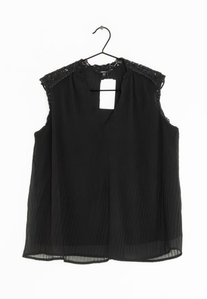 Blouse sans manches noire avec un col en V, présentant des plis texturés et des accents en dentelle sur l'épaule. Étiquette attachée visible au niveau du col.