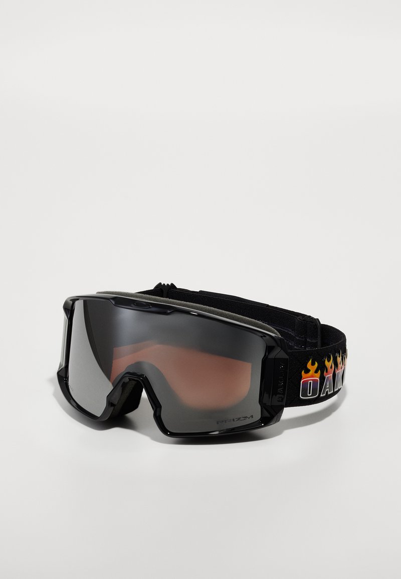 Juodi slidinėjimo akiniai su didele lęšių dalimi, pilku atspalviu ir paminkštintu rėmu. Yra raštuota juosta su "OAKLEY" ir liepsnos grafika.