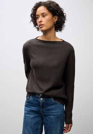 Dunkelbrauner Pullover aus weichem Strick mit weitem Ausschnitt und langen Ärmeln, kombiniert mit blauen Jeans im klassischen Fünf-Taschen-Design.