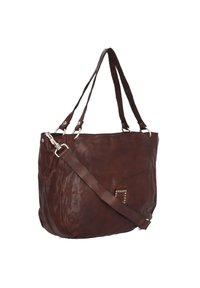 Bolso tote de cuero marrón con un diseño flexible, herrajes plateados, dos asas de hombro y un detalle con tachuelas en el frente.
