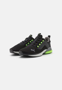 Black mesh athletic shoes with neon green accents, featuring a gray sole, textured upper, and patterned lacing system.