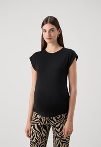 Top negro de manga corta con escote redondo, confeccionado en una tela suave. Combinado con pantalones beige que presentan un patrón de cebra en negro.