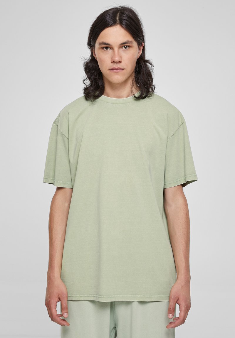 Svetlozelené oversized tričko s krátkymi rukávmi, okrúhlym výstrihom a jemnou textúrou, vyrobené z mäkkej bavlnenej látky.