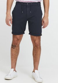 Pantaloni corti blu navy con risvolti, vita con lacci e tasche frontali. Realizzati in tessuto leggero, adatti per un abbigliamento casual.