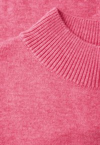 Maglioncino rosa lavorato a maglia con collo a coste. Texture morbida, finitura leggermente melangiata e cuciture uniformi visibili in tutto il tessuto.