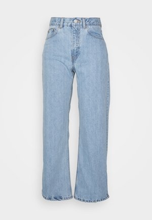 Vaqueros de pierna ancha de color azul claro hechos de mezclilla con cintura alta, que cuentan con cierre de botón y bolsillos delanteros, con un detalle de dobladillo deshilachado.