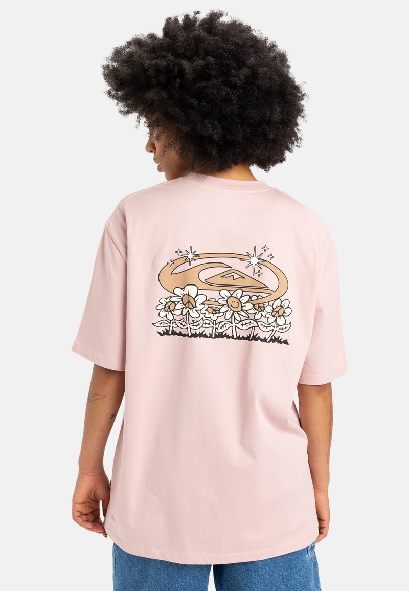 Rosa bomulds t-shirt med et grafisk print af smilende blomster og et svunget design i brun og sort på ryggen. Løs pasform, korte ærmer.