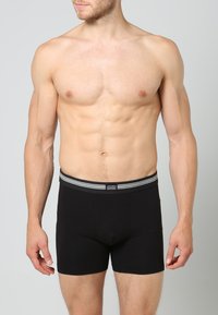 Svarta boxershorts med en mjuk elastisk midja som har grå ränder och en logotag. Tillverkade av bomull med en snug passform och utan mönster.