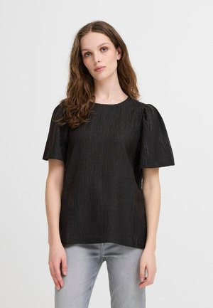 Black textured blouse with short puff sleeves, round neck, and a slightly loose fit. Worn with light gray denim jeans.