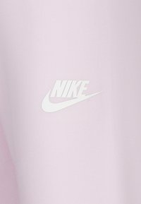 Απαλό ροζ ένδυμα με μαλακή υφή. Διαθέτει ένα εξέχον λευκό λογότυπο της Nike τυπωμένο στ ο μπροστινό μέρος, που παρουσιάζει έναν κομψό σχεδιασμό.