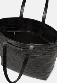 Sac à tote en cuir noir estampé de crocodile avec deux poignées, comportant une poche zippée intérieure et une doublure lisse. Design extérieur texturé.