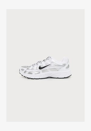 Baskets Nike P-6000 blanches et argentées avec logo Swoosh noir, semelle blanche et détails en mesh, vues de profil sur un fond uni.