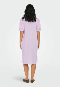 Rochie lila cu mâneci scurte și rulate, cu un croi drept, fabricată dintr-un material ușor. Prezintă un design simplu și minimalist.