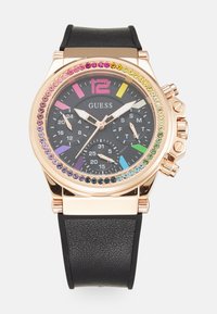 Montre Guess avec un bracelet en cuir noir, un boîtier en rose gold, une lunette en cristal multicolore et un cadran noir avec de gros index et des sous-cadrans.